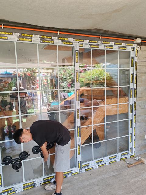 Instalador montando ventanal corredera de PVC blanco con junquillos