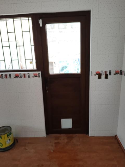Puerta de PVC nogal con vidrio y celosía de ventilación en cocina