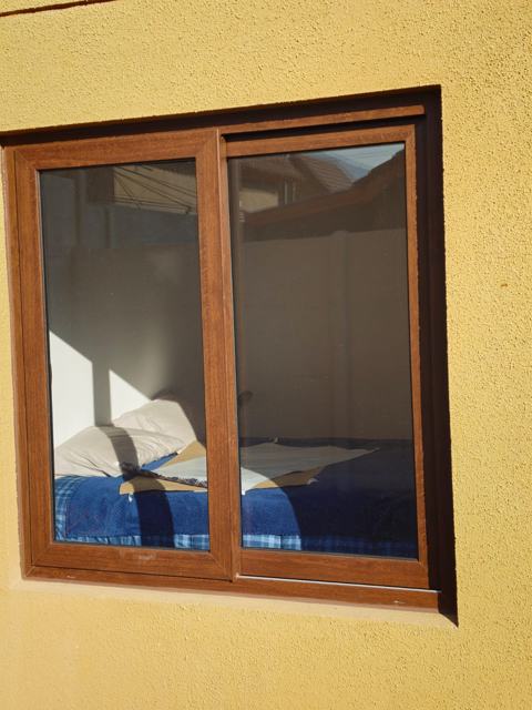 Ventana corredera de PVC roble dorado en dormitorio